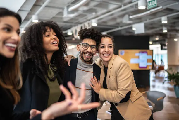 Coworkers embracing and talking at the office