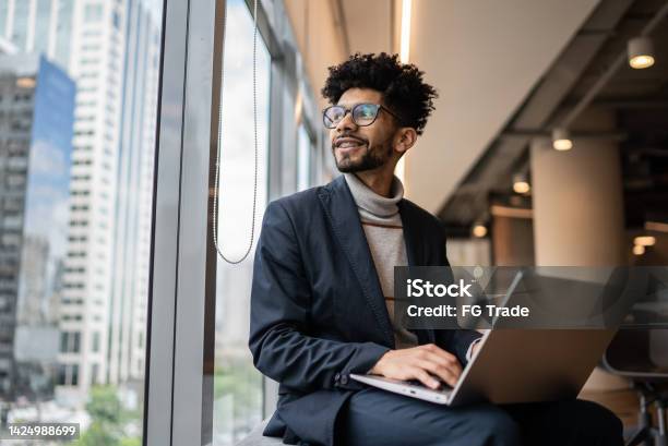 Businessman Contemplating In The Office Looking Through The Window Stock Photo - Download Image Now