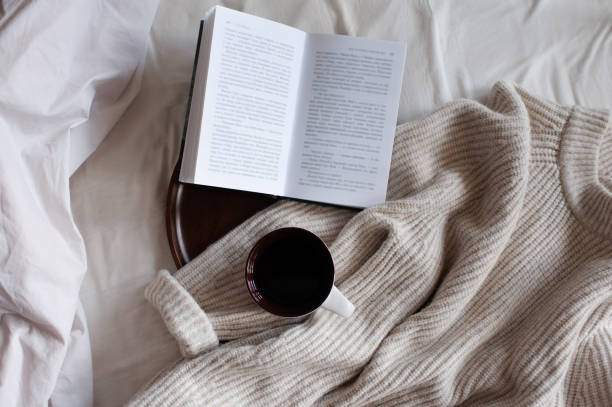 istock Reading book and drinking coffee in bed 1424991655