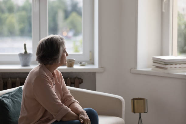istock Thoughtful lonely retired woman sitting on couch at home 1424992255
