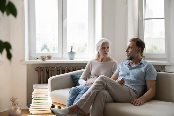 серьезная обеспокоенная пожилая пара разговаривает на домашнем диване - adult thinking love caucasian стоковые фото и изображения