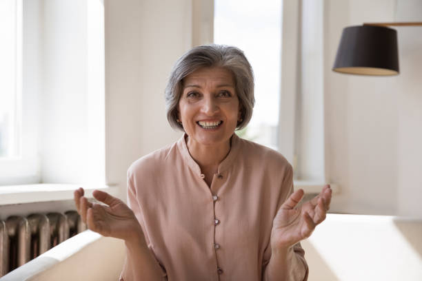 istock Happy joyful senior lady talking on video call from home 1424993085