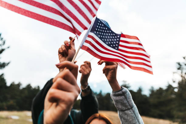 drapeaux américains levés pour les célébrations des fêtes - us veterans day photos et images de collection