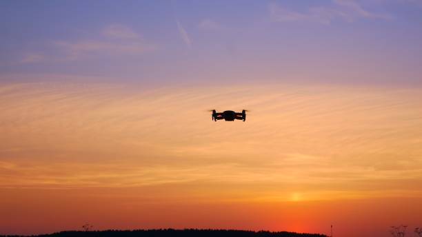istock A drone flies in the sunset sky and glows with its light bulbs. A futuristic future where drones have taken over the world. A beautiful sky in which a drone controlled by artificial intelligence flies 1424993992