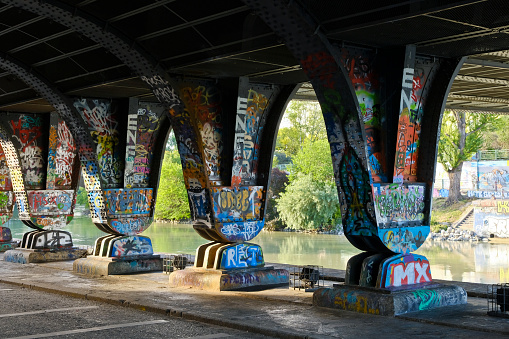 Vienna, Austria - June 17, 2022: Bridge piers decorated with graffiti on the banks of the Danube Canal.