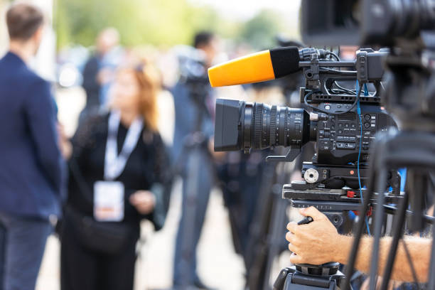 istock News conference or media interview. Shooting press event with a television camera. 1424996445