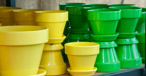 An arrangement of green and yellow flower pots stacked on a shelf in a Cape Cod garden center.