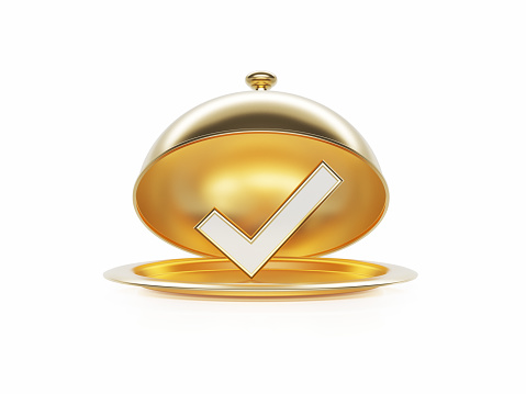 Check mark sitting inside of a gold platter sitting on white background. Horizontal composition with copy space.