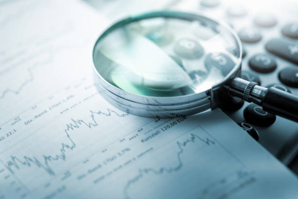 istock Magnifying glass, calculator and charts on paper 1425004878