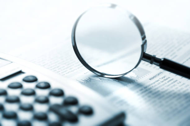 istock Magnifying glass, calculator and charts on paper 1425007639