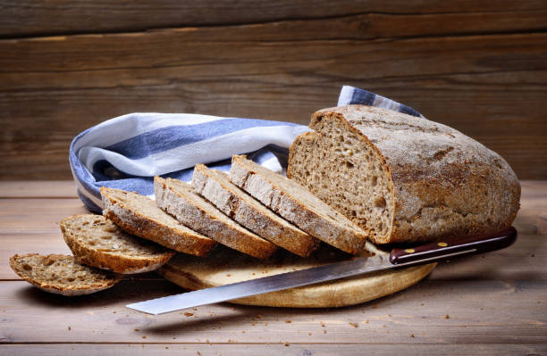 Freshly baked sliced bread on rustic wooden background.