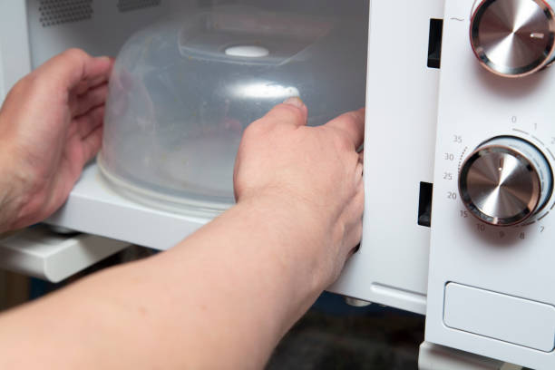 istock A person uses a microwave oven. 1425011937