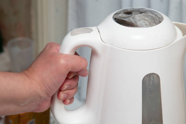 istock A person uses an electric kettle. 1425011940