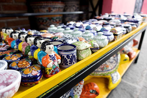 side view of mexican talvaera pottery colorful traditional talavera cups and souvenirs in a street market