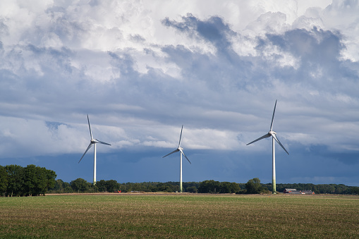 Wind turbines with dramatic sky before a storm on the countryside in Skane, Sweden.