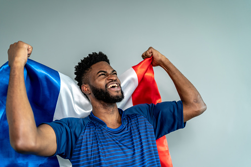 Male athlete / fan holding French flag