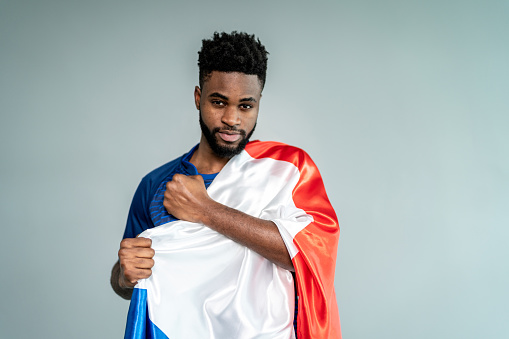 Male athlete / fan holding French flag