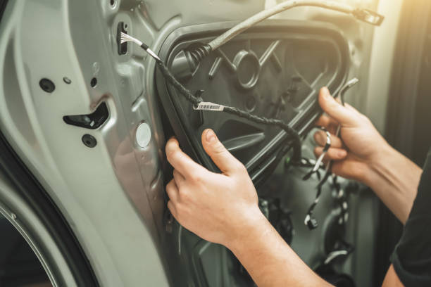 Auto service worker disassembles car door for repair close up stock photo