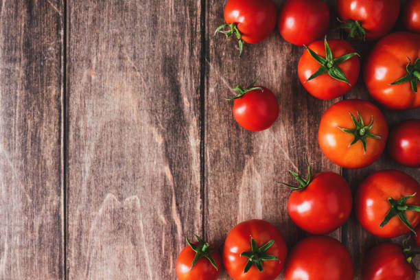 istock Tomatoes on old wooden table, fresh red tomato vegetables flat lay with copy space 1425031771