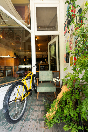 West Virginia, USA - August 12, 2022: Entrance of a locally owned art gallery with an old yellow bike and chair in the tiny mountain village of Thomas.