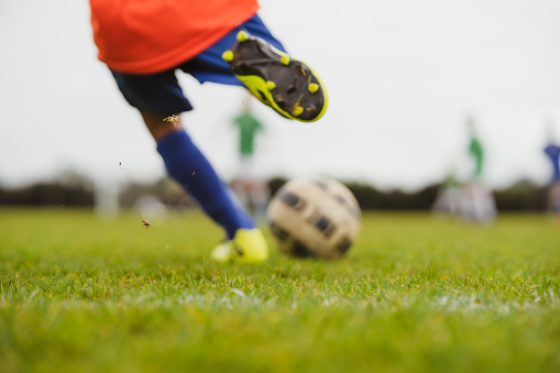 Kids playing soccer in soccer ground of a school.