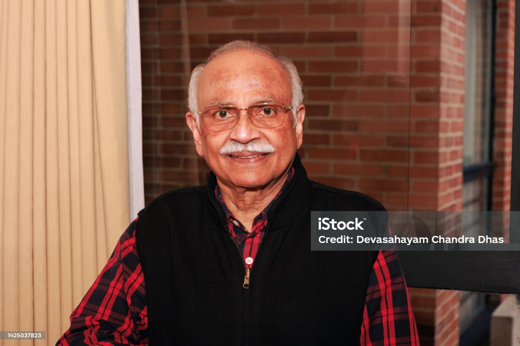 A 75 Year Old Asian Indian Man Looks Directly Into The Camera And Smiles A 75 year old Asian Indian man wearing casual clothing, looks directly into the camera and smiles. He is also wearing eyeglasses. Indian Ethnicity Stock Photo