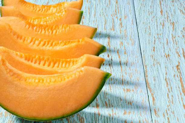 istock sliced sweet cantaloupe melon on a blue wooden table, copy space for text. 1425039281
