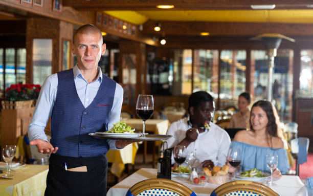istock Waiter standing with serving tray, recommending dishes in restaurant 1425040391