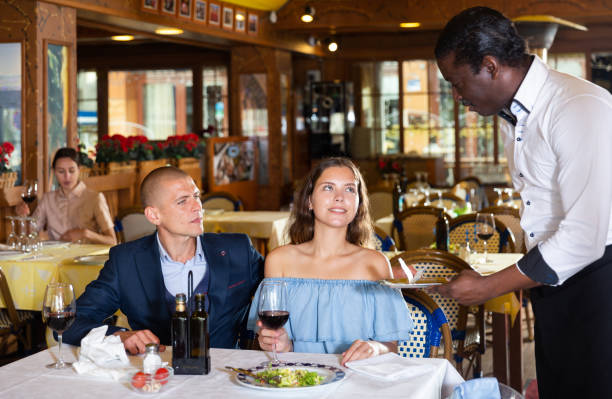 istock African-american waiter carrying order for visitors 1425040433