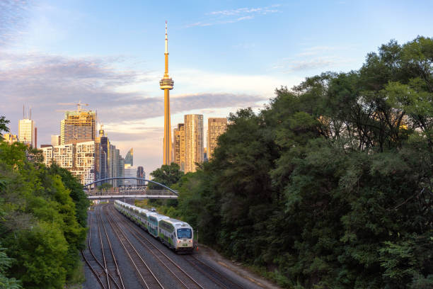 Toronto, Ontario - September 2, 2022 :  A GO Transit diesel-powered double-decker train heading to Union Station, with the CN tower in the background
