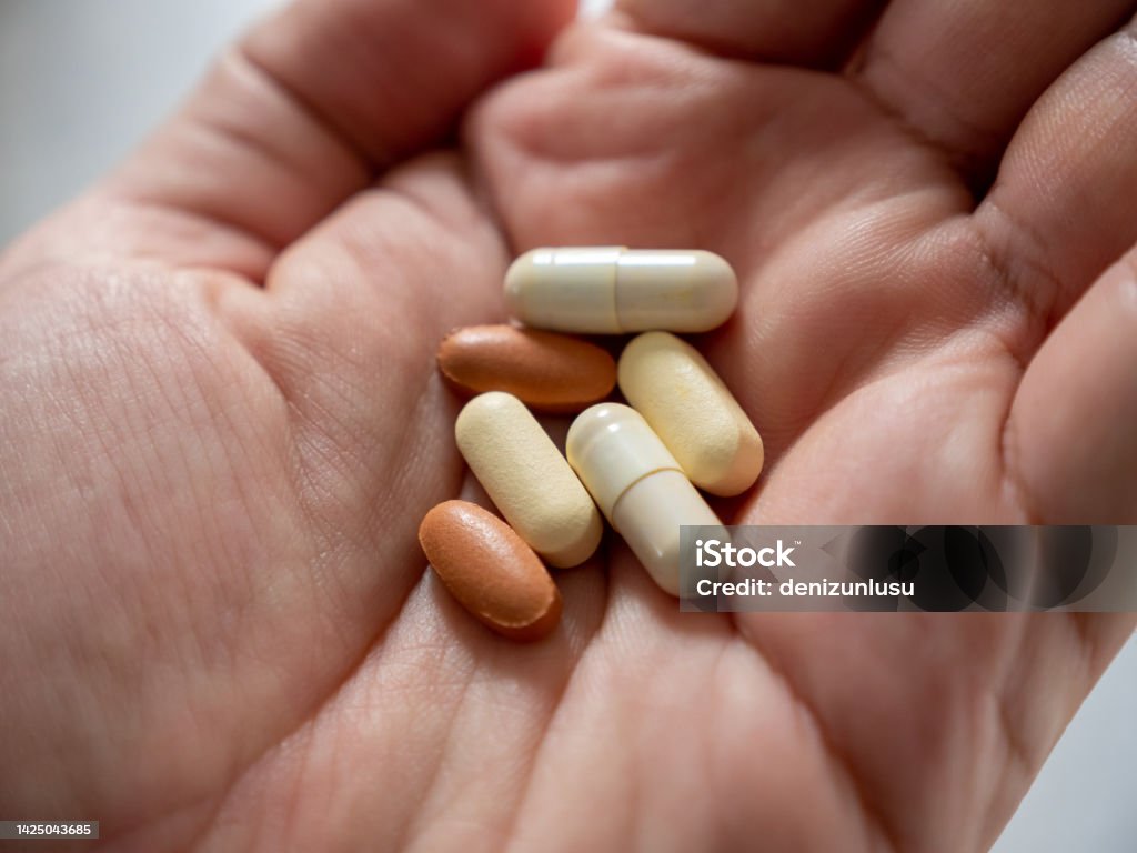 Supplemental medicines in human hand Nutritional Supplement Stock Photo