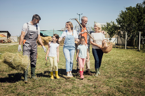 Portrait of a happy three generation family working together on their farm.