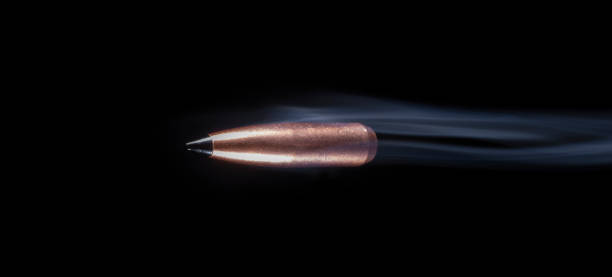 istock Copper plated bullet streaking with white smoke behind 1425044421