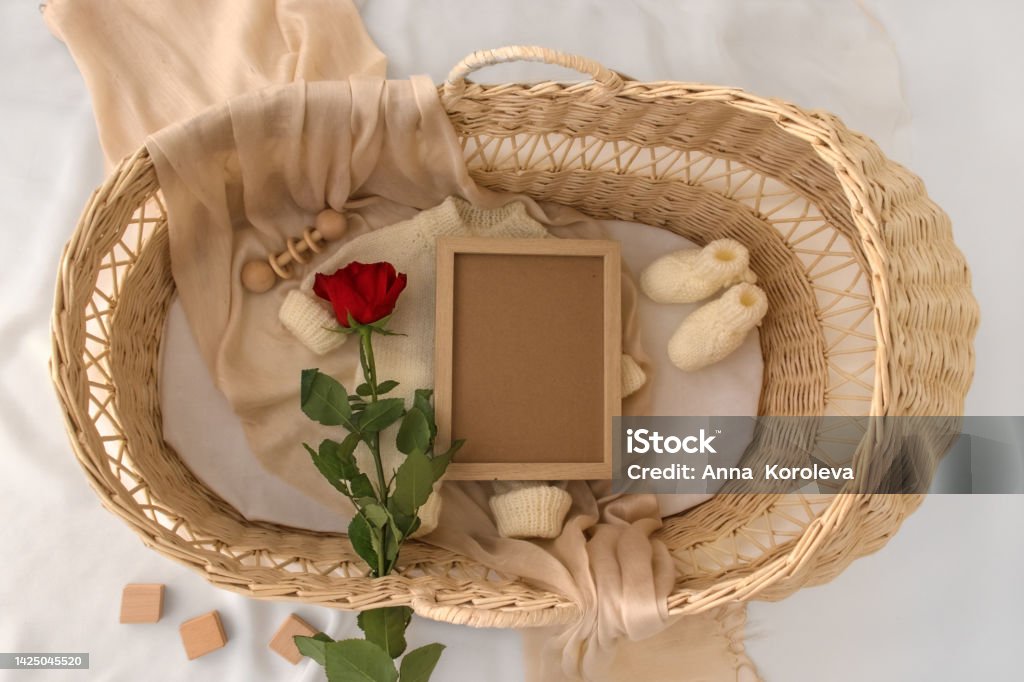Letter board Baby Announcement with basket. Baby Clothing Mock Up . Space for design . Pregnancy announcement background with blurred . Selective focus Pregnant Announcement Template. Design gender neutral bodysuit template. Layout for the design and placement with blurred . Selective focus Advertisement Stock Photo