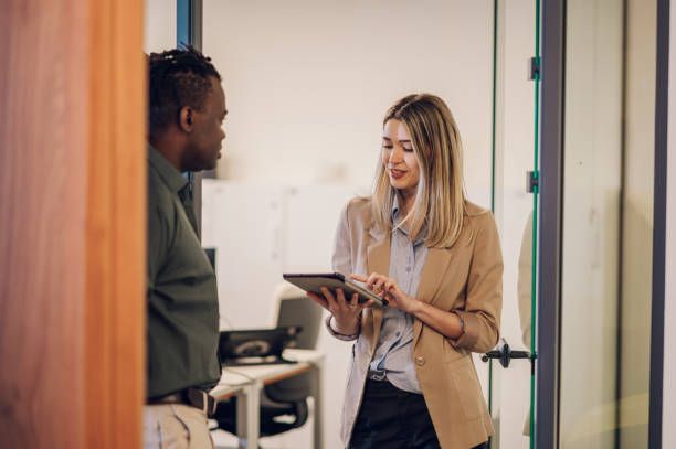 istock Two multiracial business colleagues working together on a digital tablet 1425046950