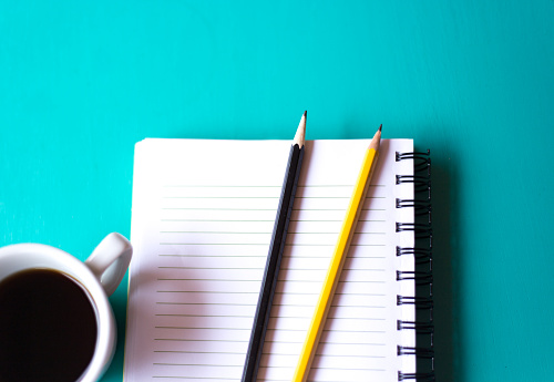 Ready to Work: Notebook, Coffee, Two Pencils, Turquoise Background