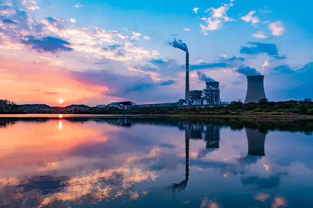 Photo of Nuclear power plant after sunset. Dusk landscape with big chimneys.