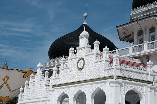 Banda Aceh, Indonesia - August 18, 2022 A small clock in the middle of the front wall of the Baiturrahman Grand Mosque