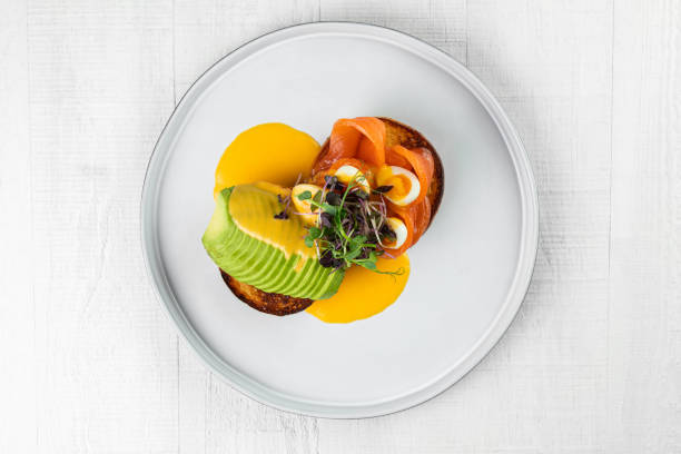 istock Delicious healthy breakfast, snack - sandwich with avocado, plates  on white table background. 1425076192