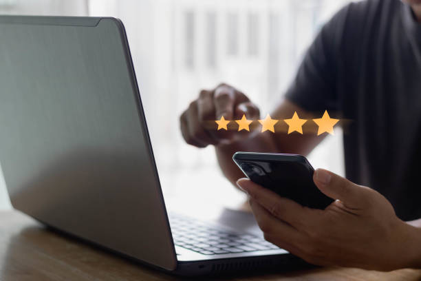 Customer service experience and business satisfaction survey concept. Close up customer hand using a smartphone to give a five-star rating. Review, feedback, Service rating, satisfaction.