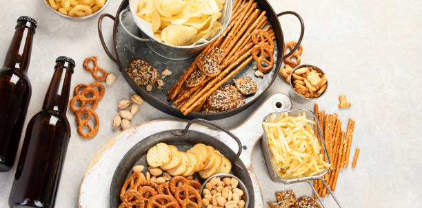 istock Assortment of beer and salty snacks on light background. 1425087245