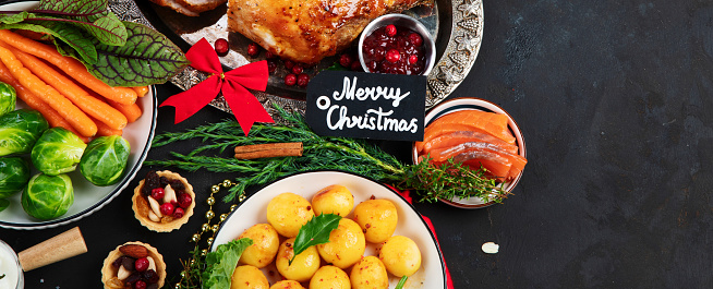 Traditional Christmas dinner on dark background. Holiday food. Top view, copy space, panorama