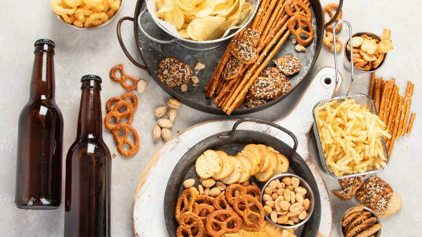 istock Assortment of beer and salty snacks on light background. 1425088271