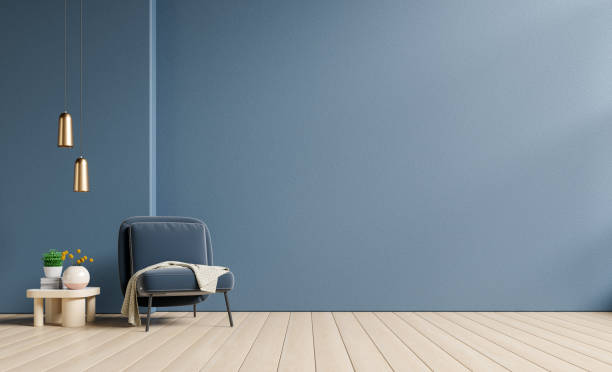 istock Empty living room with blue armchair and table on empty dark blue wall background. 1425095632