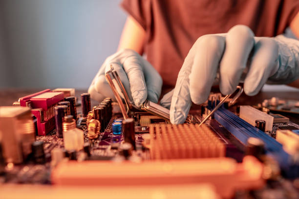 istock Engineer repairman holding hands CPU to insert into the socket of the motherboard. Technology hardware in the neon light 1425098832