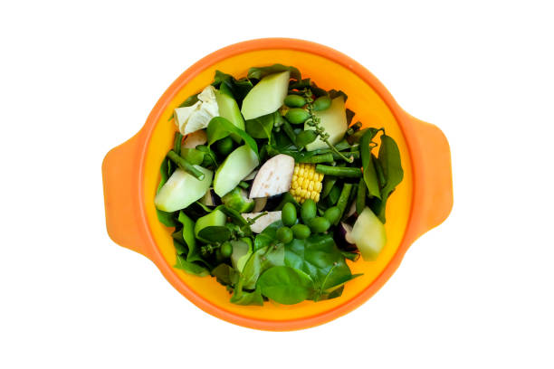 Vegetable slices of chayote, cabbage, string beans, corn and Gnetum gnemon in orange basin isolated on white background with clipping path