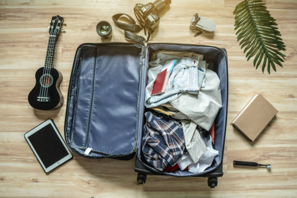 istock Packing a suitcase for a summer vacation. Preparation of things and documents for a trip to the sea by plane 1425102257