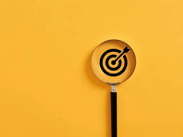 Photo of Magnifier focuses on the target icon. Focusing, finding or analyzing business goals and targets