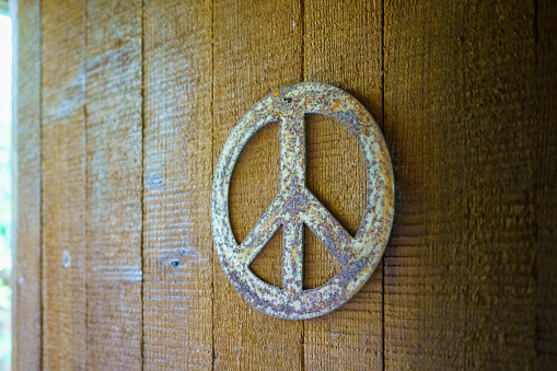 Peace sign hanging on a wall. Rusty metal