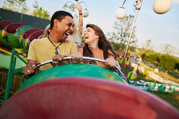 istock Cheerful couple having fun while riding on rollercoaster at amusement park. 1425113797